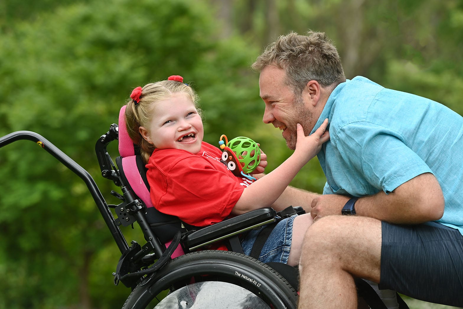 Grant recipient happy in wheel chair with father by her side