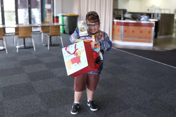 Dylan with huge smile receiving gifts from Variety