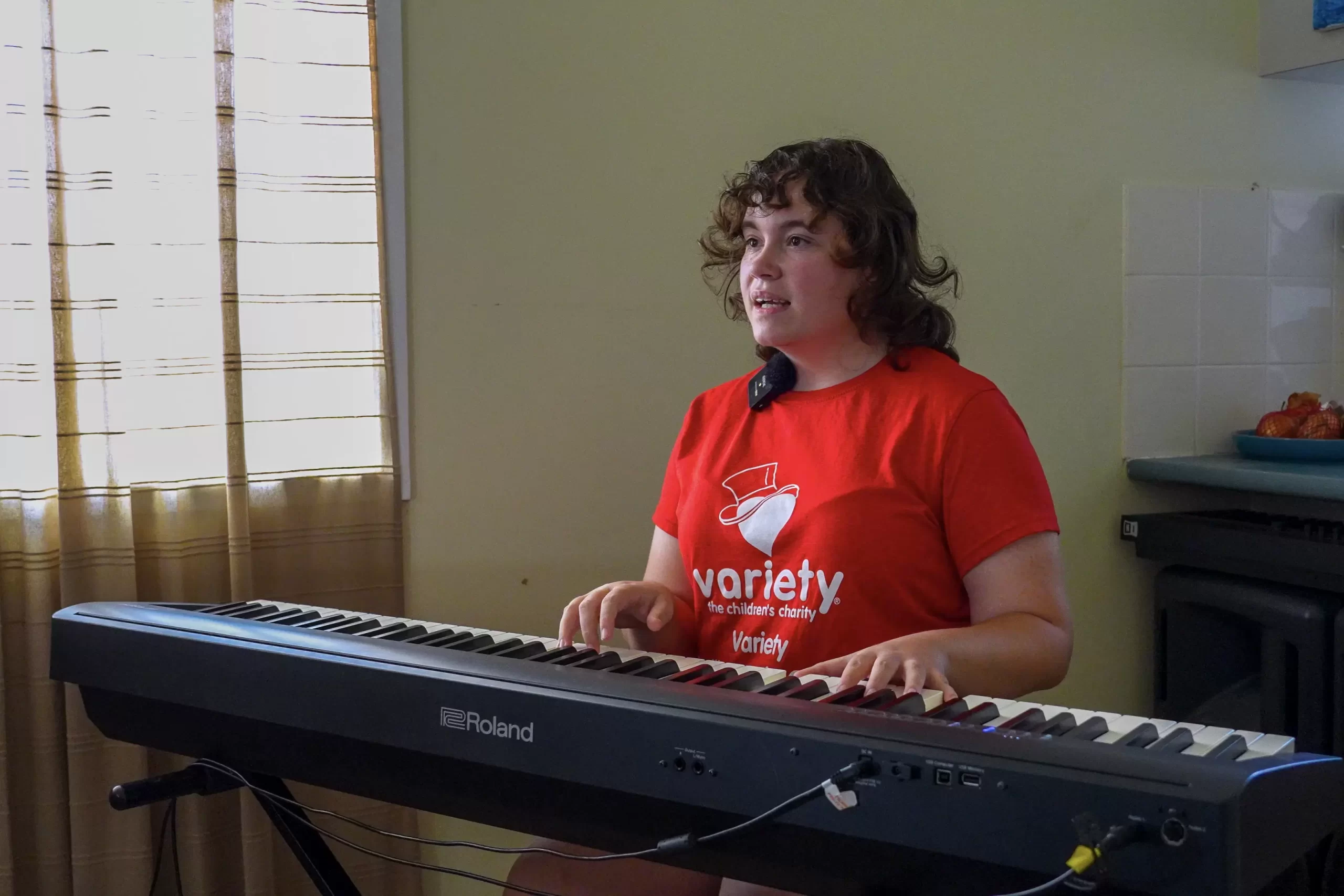 Grant recipient isabella happily playing keyboard and singing